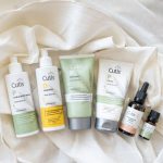 Assorted Cutis hemp seed oil hair and skincare products arranged on white fabric.
